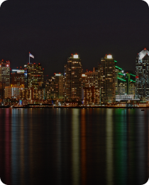 The downtown San Diego skyline at night, in the market served by Peninsula CRE Group